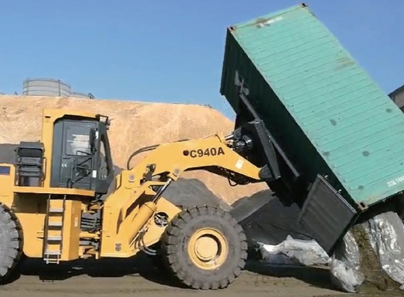 Container loader dumping recycling material